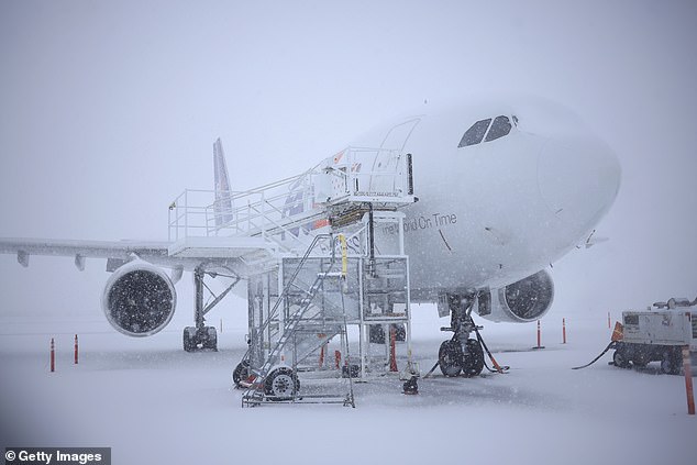 A FedEx Corp. cargo plane. is parked in the snow at Louisville Muhammad Ali International Airport on Sunday