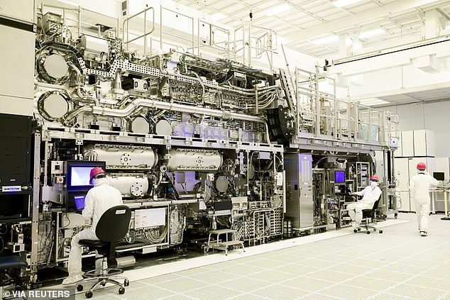 Pictured: Workers in front of a 'High NA EUV' lithography system at an Intel facility in Hillsboro, Oregon, USA.