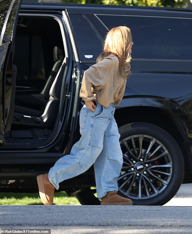 Jennifer wore a copper-toned top, baggy jeans, and platform boots.