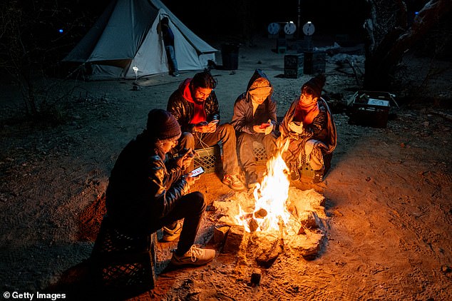 Trump promised the largest deportation in history when he took office on January 20. Migrants from Ecuador and India sit together near a fire awaiting their arrest by U.S. Customs and Border Patrol agents after crossing part of the border wall into the U.S. on Jan. 20. January 5, 2025 in Ruby, Arizona