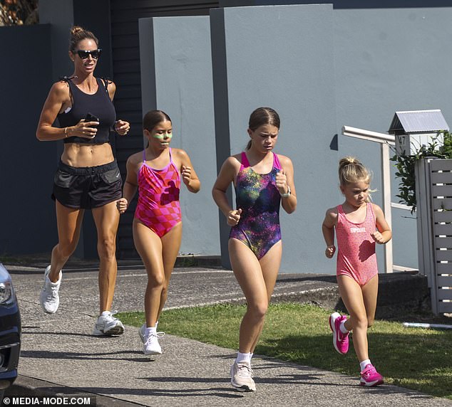 She wore dark sunglasses as she ran down the trail behind her three daughters.