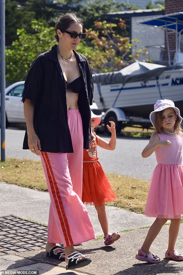 The star held her daughter's hand as she walked down to the sand.