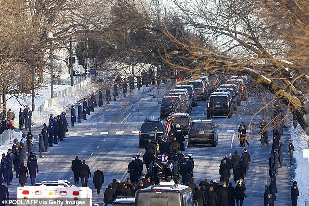 The US Army caisson detachment carries Carter's casket as people watch from the snowy streets of Washington, DC, on January 7.