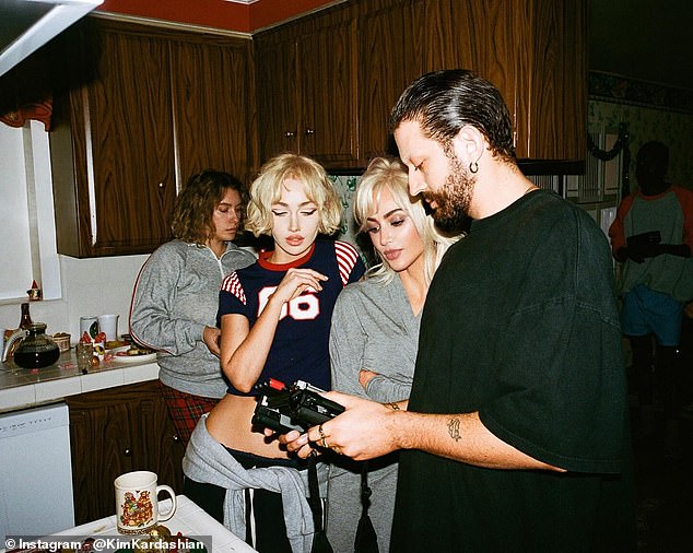 The haunting music video was directed by Nadia Lee Cohen (second left) and Charlie Denis (right), who were photographed chatting with Kim while appearing to look at some footage in the home's kitchen.