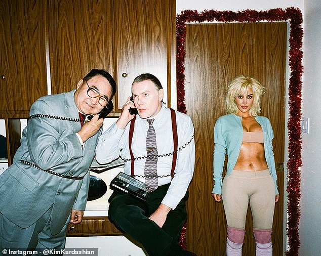 In the former kitchen, Kim posed against a door next to male actors apparently dressed as businessmen talking on landline phones with the cords wrapped around their bodies.