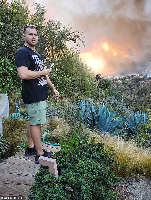 Pratt, 41, was captured in photographs watching the fire move quickly toward his home, which is in an area where many celebrity properties are also at risk of burning down.