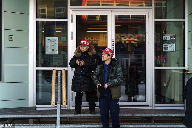 Residents wearing MAGA hats stand in front of Hotel Hans Egede during Donald Trump Jr.'s visit. (not shown) at Nuuk, Greenland