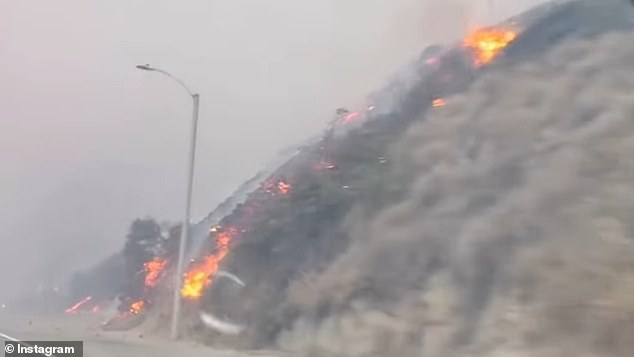 The hillside was on fire as he drove down the famous highway.