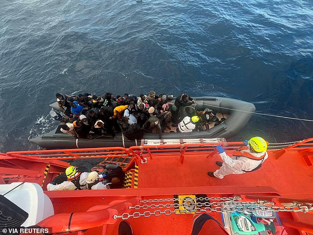 Spanish coast guards dressed in white suits work on a rescue operation while towing a rubber boat carrying migrants, including a newborn baby, off the Canary island of Lanzarote, Spain, in this image obtained on January 8, 2025. .