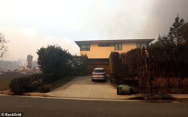 His home was surrounded by smoke and dark skies, but even the trees and bushes surrounding his home appeared largely untouched by the flames.