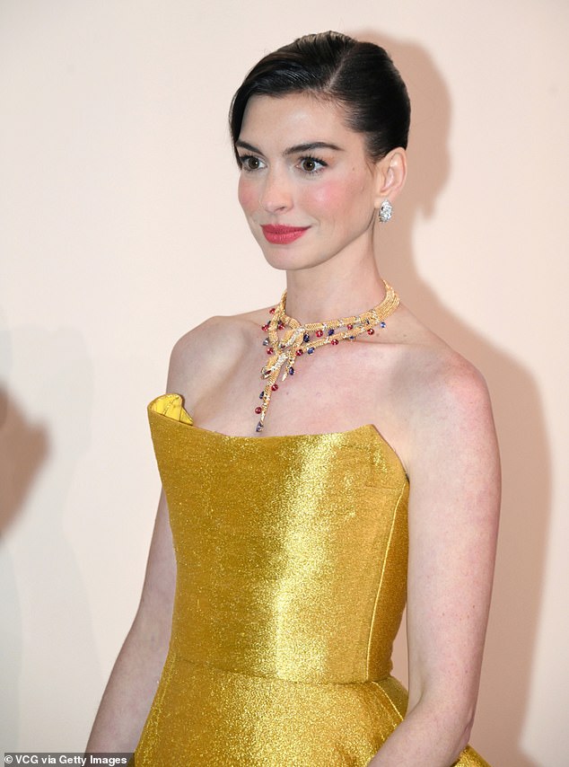 Anne accessorized her shimmering dress with a colorfully jeweled gold necklace and silver statement earrings.