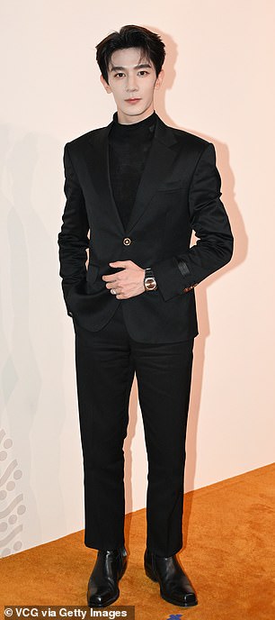 Blossom actor ZhiGuang Xia donned a black suit, patent leather dress shoes, and a wristwatch.