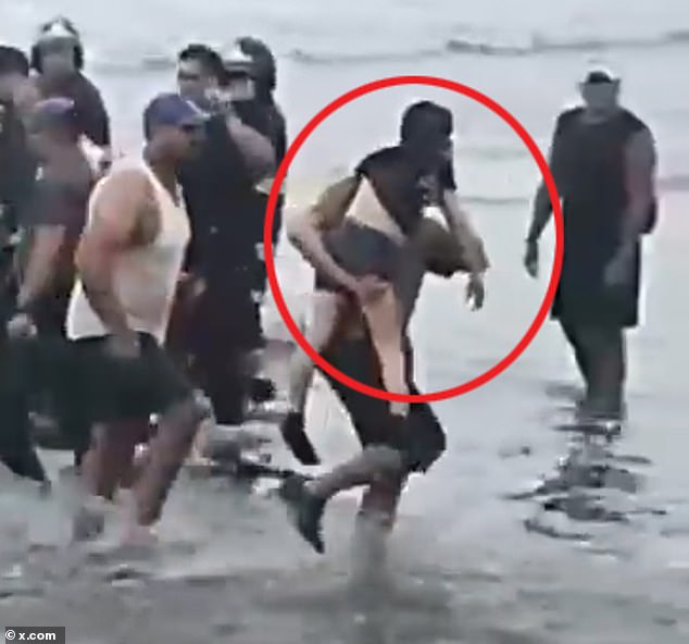 A bystander carries a young girl after she is pulled from the wreckage of the small plane