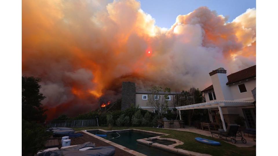 A wildfire burns near homes in Pacific Palisades, California, on January 7, 2025.