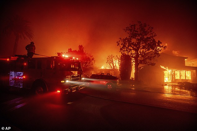 Fire crews battle fire as it burns structures in Pacific Palisades area yesterday