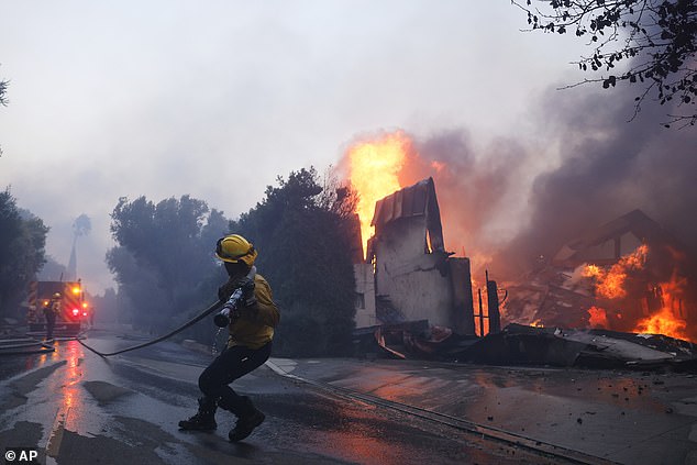 Fire crews battle fire as it burns structures in Pacific Palisades area yesterday