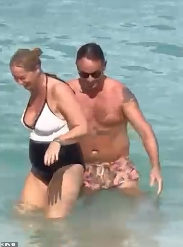 The couple were seen playing in the water in front of the five-star Fairmont Royal Pavilion hotel on the western coast of the Caribbean island.