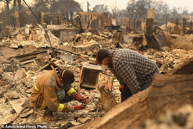 Robert Lara, left, searches for belongings with his stepfather after the Eaton Fire in Altadena, California.