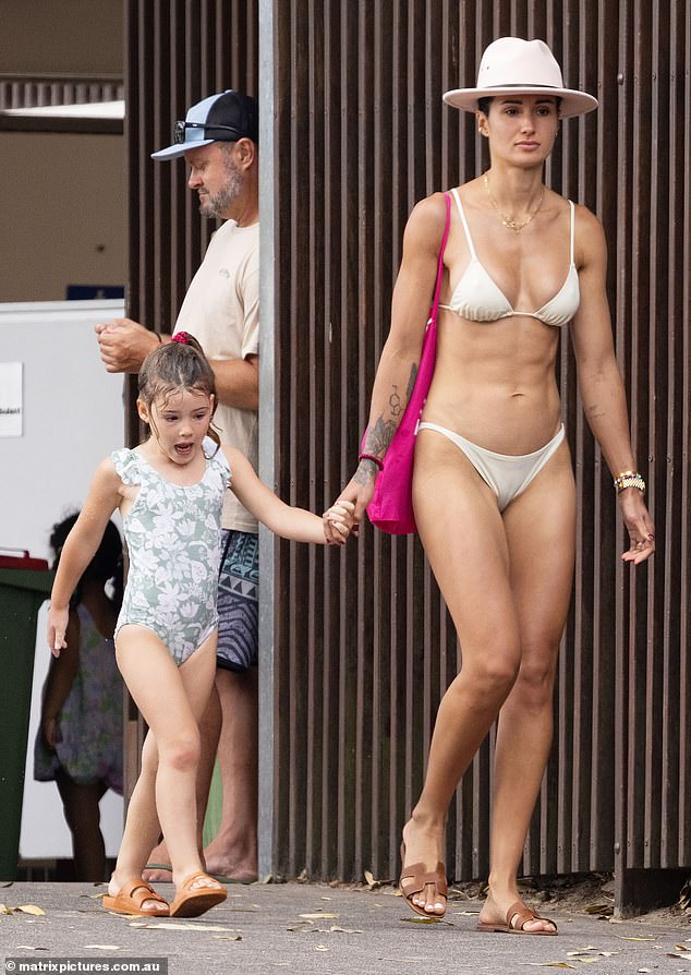 Mila looked every inch like her mother dressed in a floral print swimsuit and matching brown sandals as she held her mother's hand.