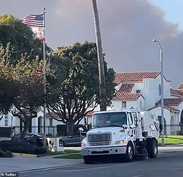 In the background, dark gray smoke billows menacingly through the air