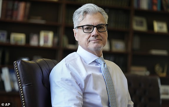 FILE - Judge Juan M. Merchan poses in his chambers in New York, March 14, 2024. Manhattan prosecutors urge the judge overseeing Donald Trump's criminal hush-money case to enforce a silence order that the Republican former president prohibits criticizing jurors and court staff, or members of the prosecution who convicted him. In court papers filed Friday, prosecutors with the Manhattan district attorney's office argued that parts of the silence order remained necessary given Trump's statements. "unique history of inflammatory and threatening public statements." (AP Photo/Seth Wenig, file)