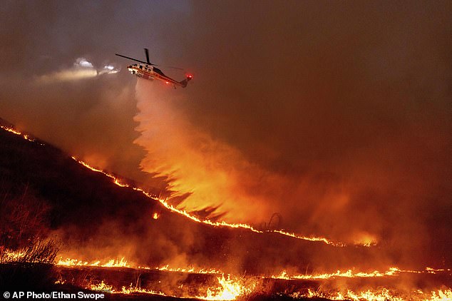 Water is dropped by helicopter on the Kenneth Fire in the West Hills section of Los Angeles, Thursday, January 9, 2025