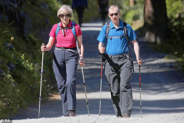 Theresa May walks through a forest with her husband Philip during a summer holiday in the Alps