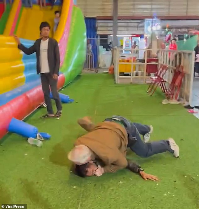 Children could be seen on a slide watching the fight unfold at the Thai market.