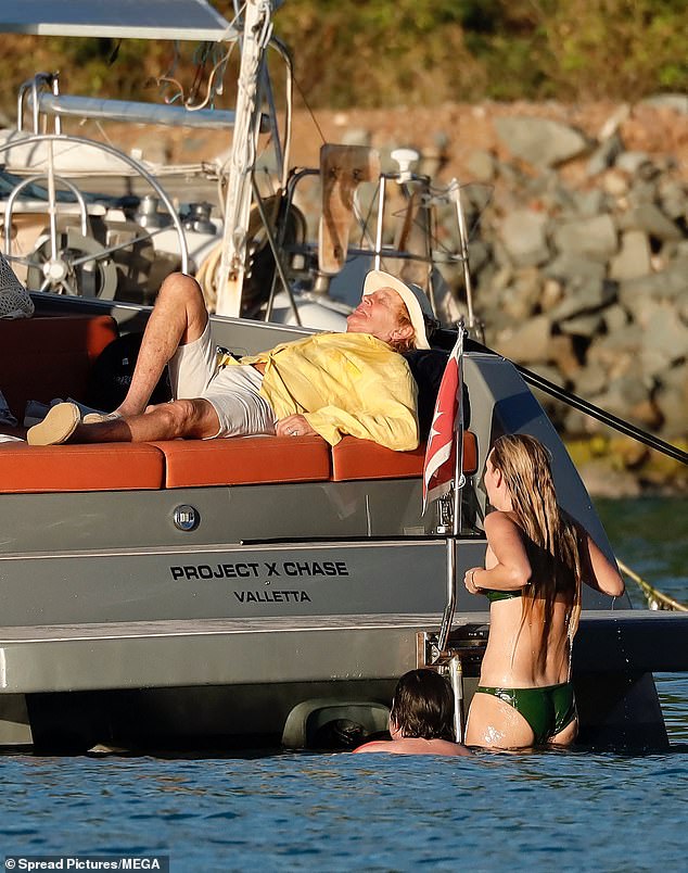 Rod looked ready for a nap as his children headed out for a swim in the sea.