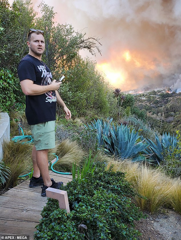 Spencer Pratt, 41, was captured in photographs watching the fire move quickly toward his home, which is in an area where many celebrity properties are also at risk of burning down.