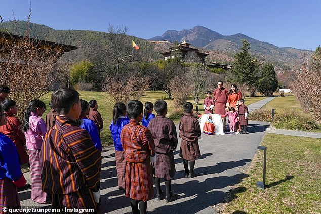 The King and Queen of Bhutan greet a group of schoolchildren in front of the picturesque mountains of Lingkana Palace in Thimphu, the country's capital, on January 2.