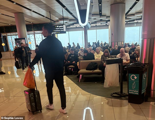 Passengers wait at Manchester Airport today after both runways were closed due to heavy snow.