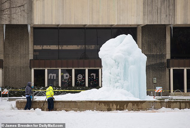 Subzero temperatures gripped Texas on February 18, 2021, as power was restored to more homes across the state overnight. Photo: Workers pick ice from a frozen fountain at the Richardson Civic Center, just north of Dallas