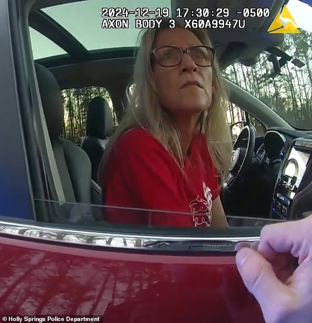 An officer is also seen talking to his wife Lynda, who appears shocked by her husband's arrest